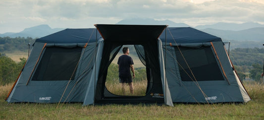 Fast Frame Odyssey 10P Tent set up on a grassy hillside, showing the large central entry and cabin-style layout.