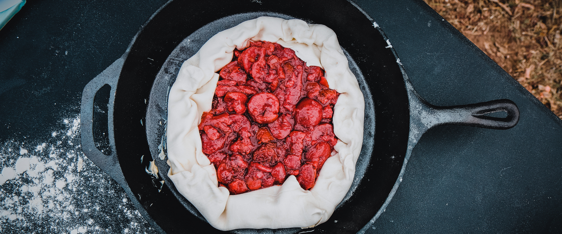 Cast iron skillet filled with a rustic berry galette ready for baking.